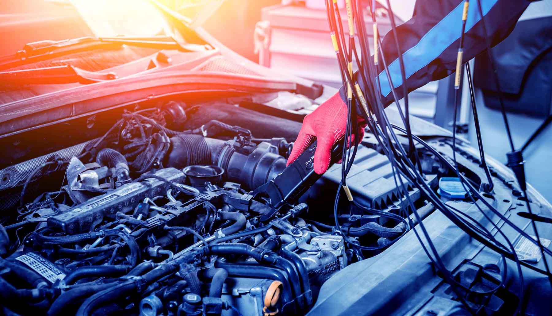 Oil Changes Car Repair Brookpark, Oh Auto mechanic uses a voltmeter to check the voltage level underneath the hood