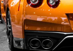 Closeup of orange car with custom muffler