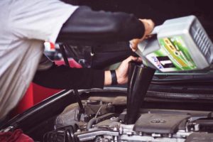 Man pouring oil into car oil change