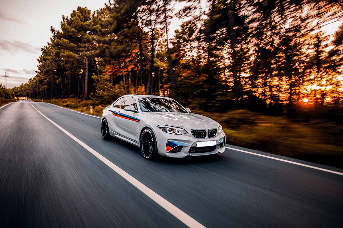 Exhaust & Suspension Repair in Brook Park, OH white-sedan-driving-highway-accross-forest copy